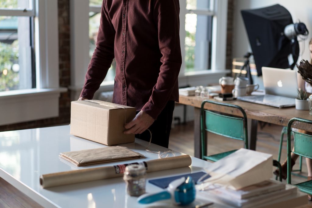 Man with red shirt putting together a subscription box package