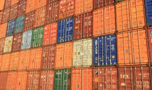 Many crates stacked on top of each other at an ocean port