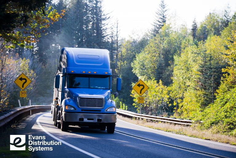 Truck driving around a bend in the road.